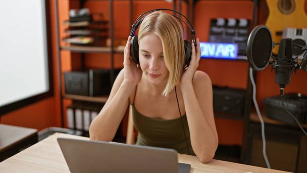 Młoda blondynka radio reporter słucha muzyki w studio podcast - Zdjęcie, obraz