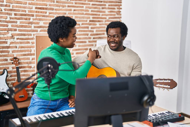 アフリカ系アメリカ人男性と女性ミュージックグループが音楽スタジオでバンプファイスト - 写真・画像