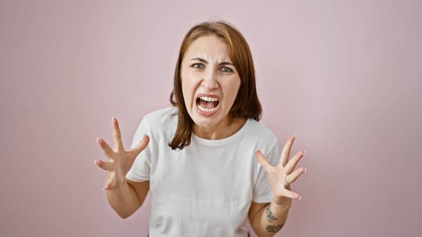 Mujer joven gritando en voz alta sobre fondo rosa aislado - Foto, Imagen