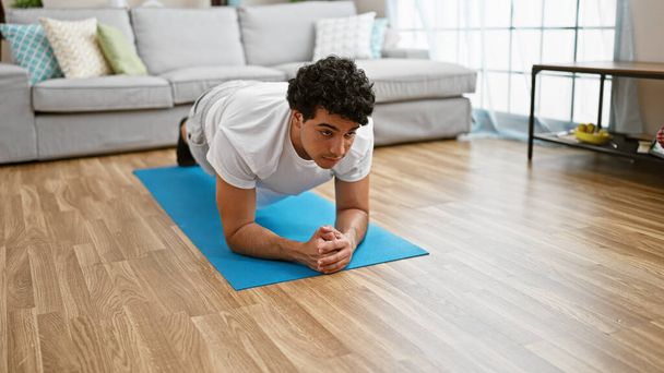 młody Latynos człowiek szkolenia core ćwiczenia w domu - Zdjęcie, obraz