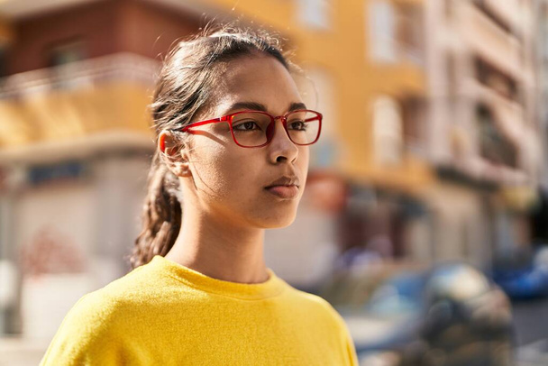 Fiatal afro-amerikai nő szemüveget visel nyugodt kifejezés az utcán - Fotó, kép
