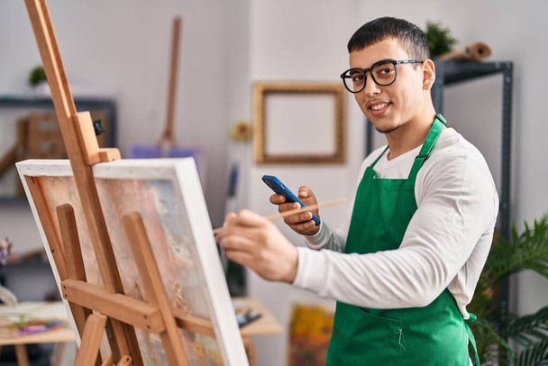 Jeune homme artiste utilisant un smartphone dessin au studio d'art - Photo, image