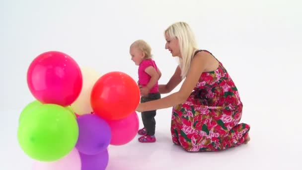 Madre y su bebé jugando con globos multicolores
 - Metraje, vídeo