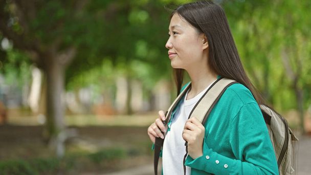 Joven turista china con mochila sonriendo en el parque - Foto, imagen