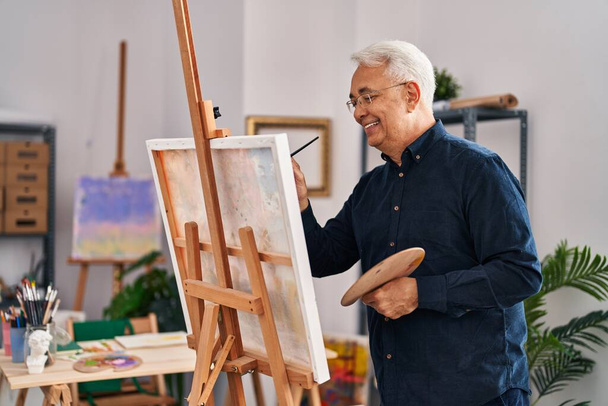 Uomo anziano sorridente disegno fiducioso a studio d'arte - Foto, immagini