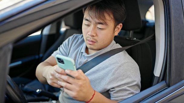  usando el teléfono inteligente sentado en el coche en la calle - Foto, imagen