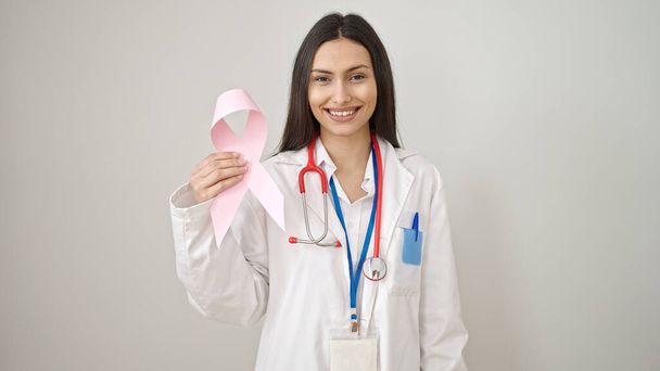 Jeune belle femme hispanique médecin tenant le cancer du sein conscience ruban rose sur fond blanc isolé - Photo, image