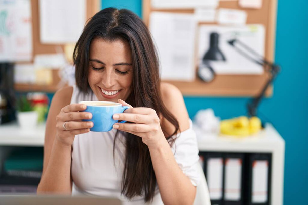 Młoda piękna latynoska kobieta biznes pracownik pije kawę w biurze - Zdjęcie, obraz