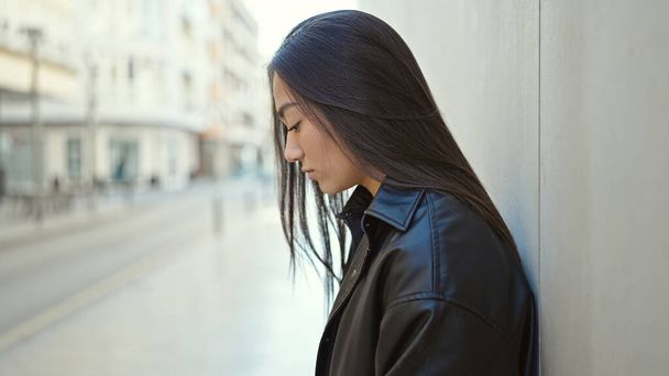 Молода красива іспаномовна жінка дивиться на бік з сумним виразом на вулиці
 - Фото, зображення