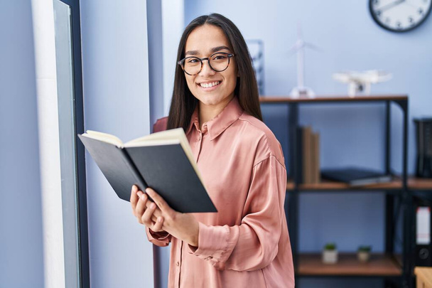 Młoda latynoska kobieta biznes pracownik czytania książki w biurze - Zdjęcie, obraz