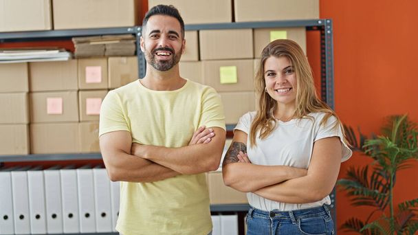 Man and woman ecommerce business workers standing together with arms crossed gesture at office - Photo, Image