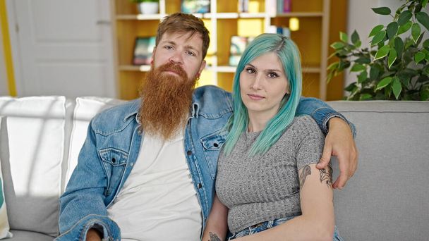 Uomo e donna coppia che si abbracciano seduti sul divano a casa - Foto, immagini