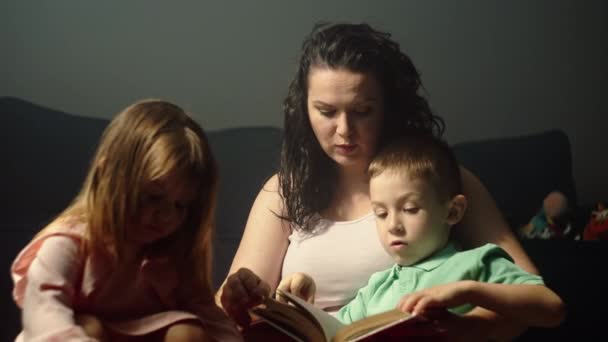 Mama liest ein Märchenbuch für Kinder. Eine glückliche Familie mit Kindern verbringt Zeit miteinander, einen Lebensstil der elterlichen Liebe und Aufmerksamkeit für Kinder. Hochwertiges 4k Filmmaterial - Filmmaterial, Video