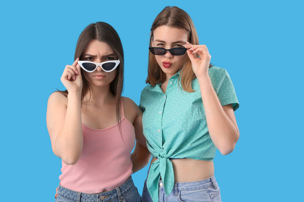Жінки-друзі в сонцезахисних окулярах на синьому фоні - Фото, зображення