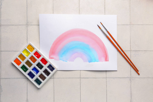 Σχέδιο πολύχρωμου ουράνιου τόξου με χρώματα και πινέλα καλλιτέχνη σε μπεζ φόντο πλακιδίων - Φωτογραφία, εικόνα