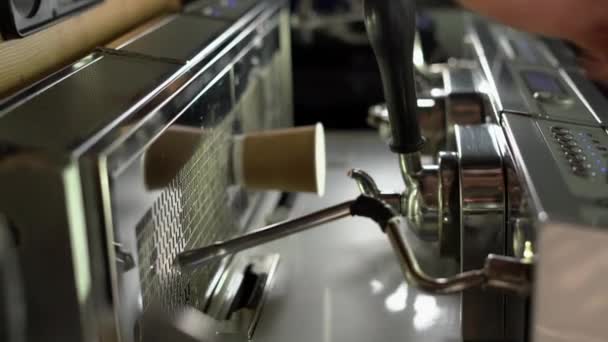 Varón barista bate leche para un café con leche en una jarra de acero en la máquina de café. Vídeo vertical - Metraje, vídeo