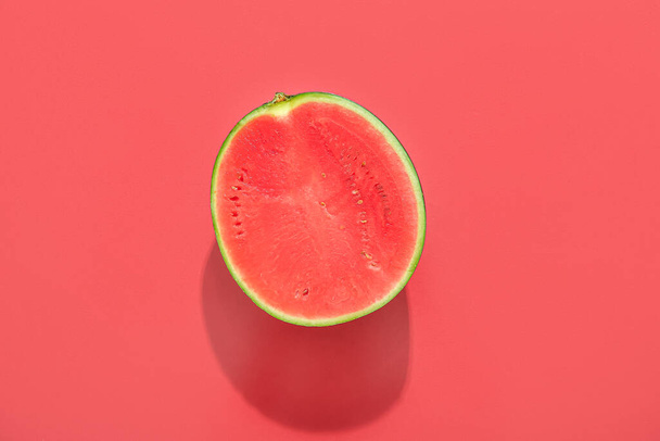 Die Hälfte der reifen Wassermelone auf rotem Hintergrund - Foto, Bild