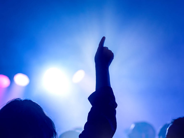 Kädet ylös! Yöelämän ja diskon käsite. Ihmiset tanssivat klubeilla. Valikoiva fokus - Valokuva, kuva