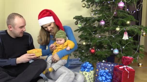 幸せな家族の男と女は赤ん坊の娘のギフトを示す - 映像、動画