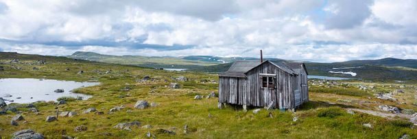 zatažená obloha nad stodolou a skalami na pláni hardangerviddy v Norsku - Fotografie, Obrázek