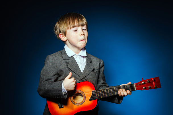 Red-haired preschooler boy with ukalele, music concept - Foto, Bild