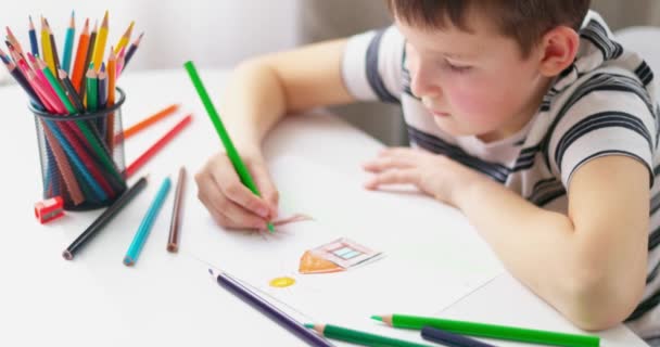 Lindo dibujo de niño en un pedazo de papel con lápices de color en casa o en el aula. Aprendizaje de niños dibujando. Concepto educativo. Imágenes de alta calidad 4k - Metraje, vídeo