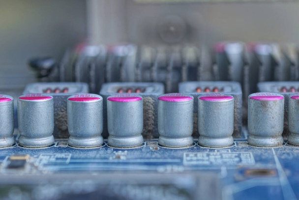 egy régi kék mikroáramkör része, sorszürke fém kis alkatrészek hordóival egy elektromos készüléken - Fotó, kép