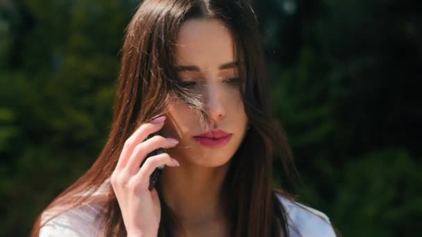 Lähikuva järkyttynyt turhautunut arabialainen nainen puhuu matkapuhelimella ulkona saavat huonoja uutisia huolissaan stressaantunut tyttö opiskelija liikenainen vastaa liikepuhelu matkapuhelimeen tuntuu negatiivinen tunne ongelma - Materiaali, video