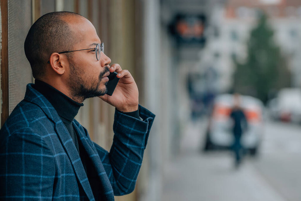 obchodní latinsky muž na ulici mluvit na mobilní telefon nebo smartphone - Fotografie, Obrázek