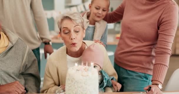 Happy family, birthday and senior woman celebration, having fun and bonding in their home together. Cake, candle and grandmother with children in a house for party, celebrating and event with love. - Footage, Video