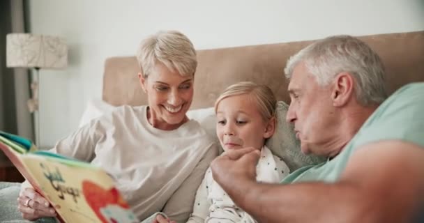 Grandparents, child and reading books in bedroom for learning, language development and quality time. Senior man, woman and happy kid relax for funny storytelling and support together in family home. - Footage, Video