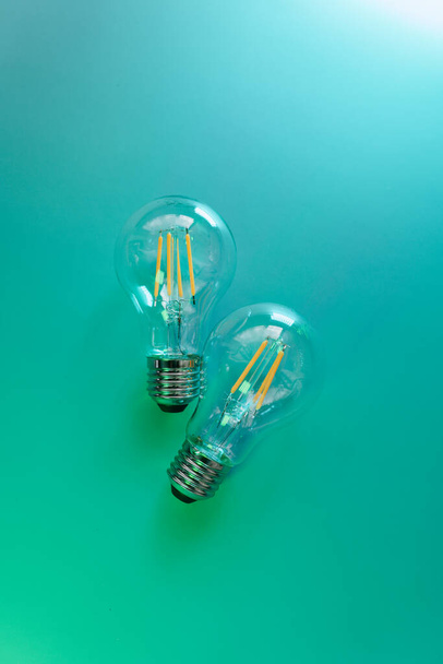 L'énergie verte. Ampoules électriques sur fond turquoise avec dégradé bleu.Coût de l'électricité. - Photo, image