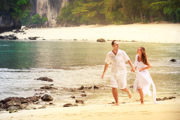 Braut und Bräutigam laufen am Strand - Foto, Bild