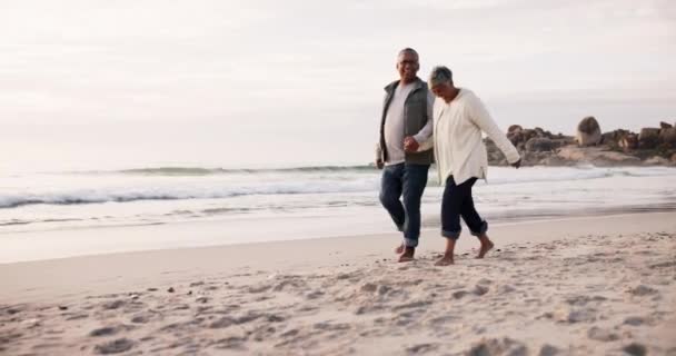 Coppia, passeggiate e tenersi per mano sulla spiaggia, vacanza e vacanza in un'isola tropicale in pensione o viaggiare con amore. Felice, persone anziane e camminare sulla sabbia insieme con la felicità nel matrimonio. - Filmati, video