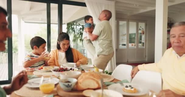 Family breakfast, playing and talking in living room for eating and quality time together. Happy, house and parents, grandparents and children at table for food, lunch or conversation in the morning. - 映像、動画