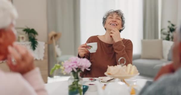 Чай, смішна і старша жінка з друзями в домашній вітальні, спілкуючись і розмовляючи за столом. Щасливі люди, літня людина та сміються над комедією, історією та посмішкою для розмови, пліток та кави. - Кадри, відео