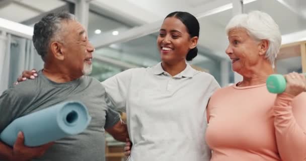 Idősebb ápoló, segítő és gyógytornász idős párral, súlyzóval és egészségügyi ellátással az idősek otthonában. Fizika, testmozgás és nyugdíjazás, fitneszedző, valamint idős férfi és nő a mobilitási képzési klinikán. - Felvétel, videó