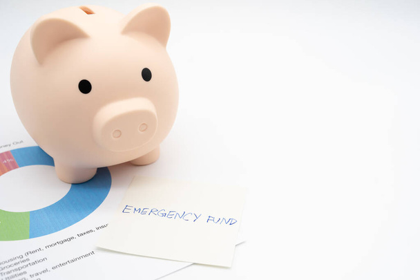 Concept of emergency savings fund. A piggy bank with paper note Pension Plan. Piggy bank and graph for saving emergency money.  - Photo, Image