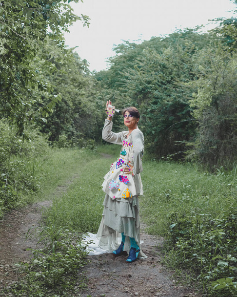 Retrato de una drag queen en un paisaje rural. Retrato de una persona de género no binario que interactúa con la naturaleza. - Foto, imagen