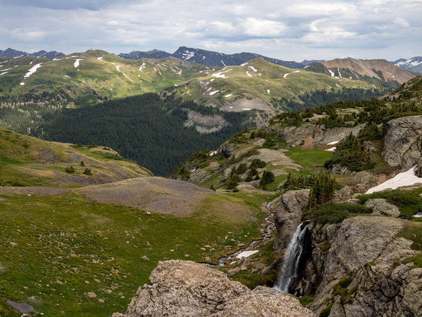Schöne Landschaft mit Wasserfall und Bergen im Hintergrund. Im Sommer noch etwas Schnee auf den Gletschern - Foto, Bild