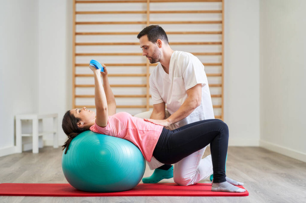 The physiotherapist performing rehabilitation exercises with the patient. - Photo, Image