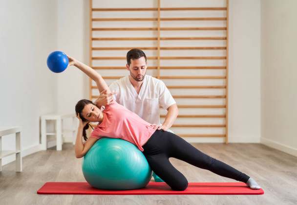 The physiotherapist doing rehabilitation exercises with the patient - Photo, Image