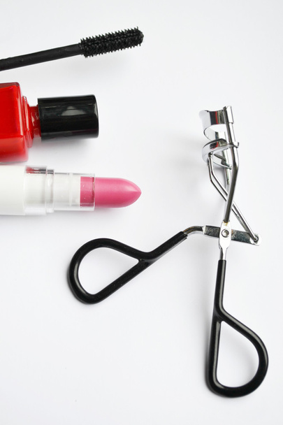Kosmetik-Set mit schwarzer Mascara, rosa und rotem Nagellack und Lippenstift und Wimpernzange isoliert auf weiß - Foto, Bild