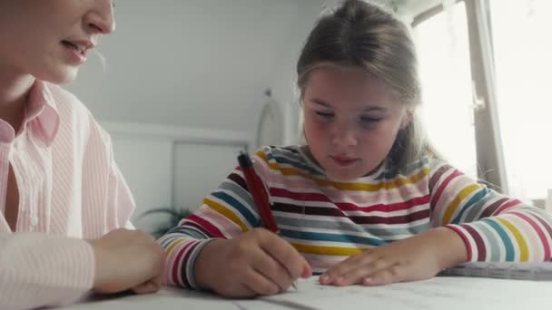 Mother helping daughter in doing homework. Shot with RED helium camera in 8K.  - Séquence, vidéo