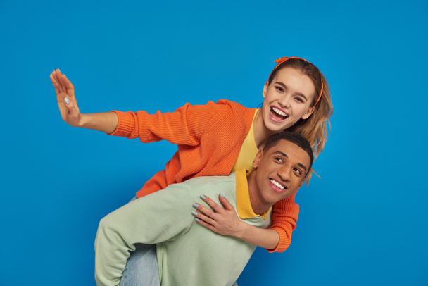 радісна афроамериканська людина, весела дівчина на синьому фоні, пара розважається - Фото, зображення