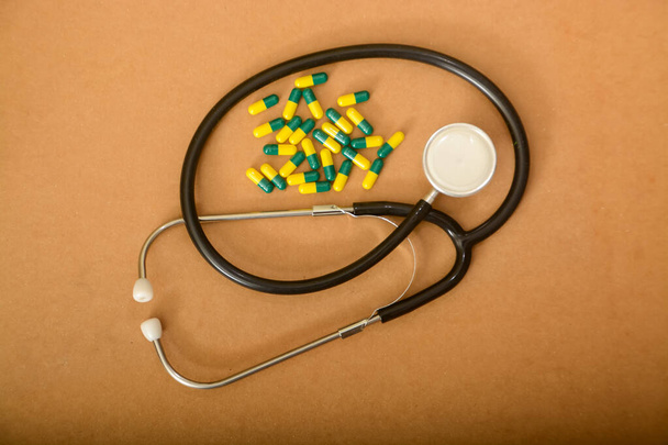 Stetoskop i kapsułki po tabletkach. profilaktyka i leczenie chorób serca, opieki zdrowotnej i medycyny - Zdjęcie, obraz