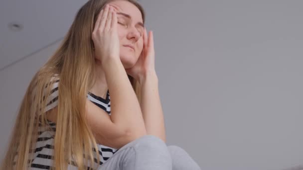 Moe jonge vrouw aanraken voorhoofd met hoofdpijn, migraine of depressie, overstuur gefrustreerd meisje verontrustend probleem, gevoel van stress, verdriet concept. - Video
