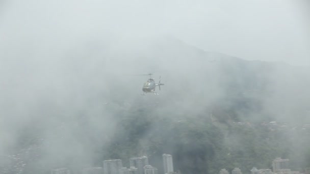 Helicopter comes towards camera through clouds, then goes behind trees - Séquence, vidéo
