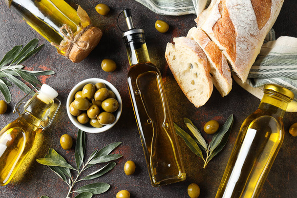 Bir şişe zeytinyağı, zeytin ve ekmek dilimleri gri arka planda, üst manzara - Fotoğraf, Görsel