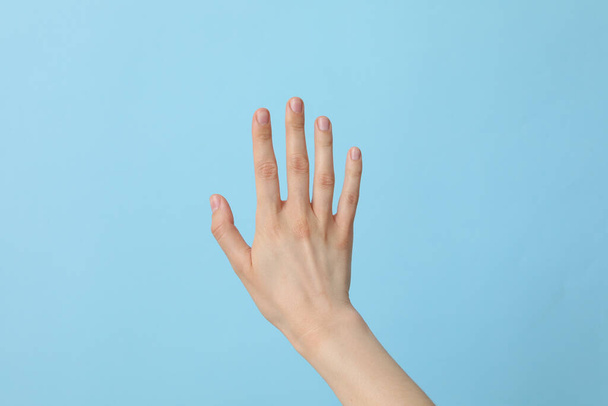 Kobieta zadbana ręka na jasnoniebieskim tle - Zdjęcie, obraz